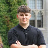 Young man in black shirt at Mayo Dark Sky Festival venue, with historic building in background.