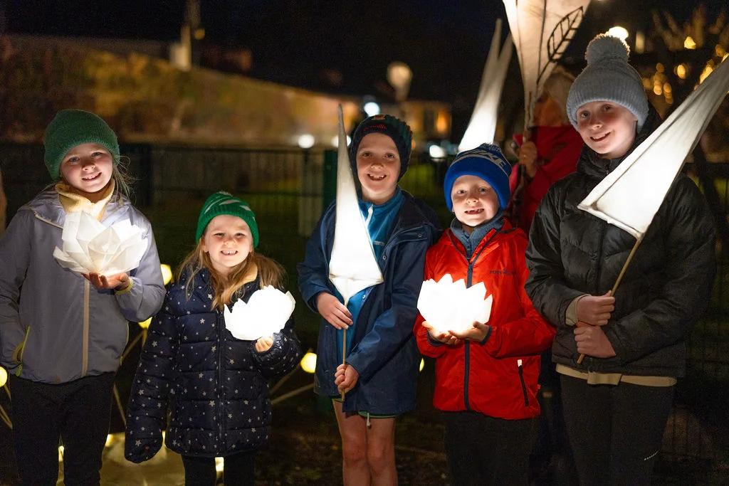 Children holding lanterns at Mayo Dark Sky Festival night event in Ireland, enjoying a captivating outdoor gathering.